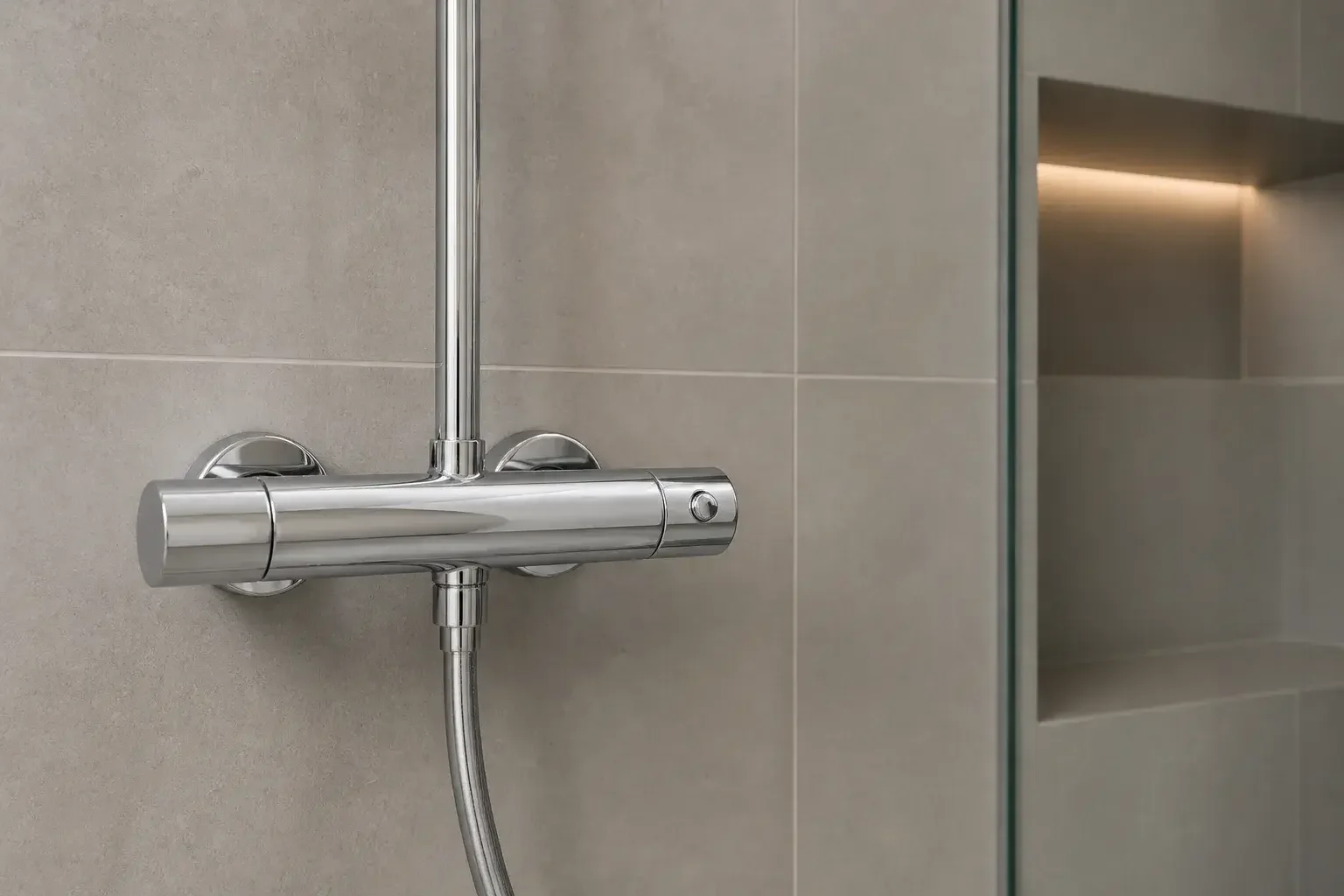 Detalle limpio de grifería y alicatado en un baño terminado.